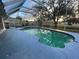 This spacious screened-in pool has a tiled deck and a peaceful view of the backyard at 269 Rosemary St, Port Charlotte, FL 33954