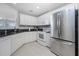 Modern kitchen with white cabinets, granite countertops, and stainless steel appliances at 255 W End Dr # 3211, Punta Gorda, FL 33950