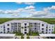 Aerial view of a modern apartment building with parking and tropical landscaping at 14131 Heritage Landing Blvd # 838, Punta Gorda, FL 33955