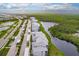 Aerial view of modern condo community by a lake with lush landscaping at 14131 Heritage Landing Blvd # 838, Punta Gorda, FL 33955
