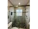 Large walk-in shower with modern gray tile and hexagon floor tile at 7739 38Th N Pl, St Petersburg, FL 33709
