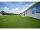 Tan house exterior with backyard and grassy lawn at 16 Tee View Rd, Rotonda West, FL 33947