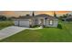 House exterior with a three-car garage and well-maintained lawn at 16 Tee View Rd, Rotonda West, FL 33947