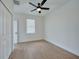 Bright bedroom with ceiling fan, wood-look floors, and ample closet space at 16 Tee View Rd, Rotonda West, FL 33947