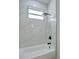 Clean bathroom with a shower/tub combo and marble tile at 16 Tee View Rd, Rotonda West, FL 33947