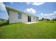 Tan house exterior with backyard and grassy lawn at 16 Tee View Rd, Rotonda West, FL 33947