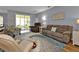 Spacious living area featuring a relaxing seating arrangement and access to a sunroom at 24703 Buckingham Way, Punta Gorda, FL 33980