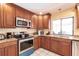 Kitchen corner with stainless steel appliances and wood cabinets at 2216 Pellam Blvd, Port Charlotte, FL 33948