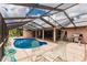 Inviting kidney-shaped pool with screened enclosure, providing ample space for relaxation and entertainment at 2216 Pellam Blvd, Port Charlotte, FL 33948