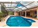 Relaxing kidney-shaped pool with screened enclosure, perfect for outdoor enjoyment at 2216 Pellam Blvd, Port Charlotte, FL 33948