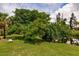 Peaceful waterfront view with lush landscaping and mature trees at 2216 Pellam Blvd, Port Charlotte, FL 33948