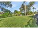 Green grassy backyard with pond and tropical plants at 286 Mark Twain Ln, Rotonda West, FL 33947