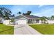 Newly built home with a white garage door and nicely landscaped lawn at 286 Mark Twain Ln, Rotonda West, FL 33947