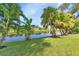 Serene pond-side backyard with tropical foliage at 286 Mark Twain Ln, Rotonda West, FL 33947