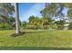 Landscaped backyard with pond view and lush lawn at 286 Mark Twain Ln, Rotonda West, FL 33947