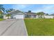 Ranch style home with a large grassy yard and driveway at 286 Mark Twain Ln, Rotonda West, FL 33947