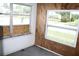 Sunroom featuring wood paneling and street views at 702 W Olympia Ave, Punta Gorda, FL 33950