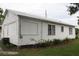 White house with side yard and mature trees at 702 W Olympia Ave, Punta Gorda, FL 33950