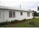 White house with side yard and mature trees at 702 W Olympia Ave, Punta Gorda, FL 33950