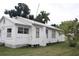 White house with side yard and mature trees at 702 W Olympia Ave, Punta Gorda, FL 33950