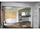 Dated kitchen features white cabinets, stove, and damaged flooring at 702 W Olympia Ave, Punta Gorda, FL 33950