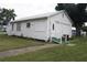 White house with side yard, ramp, and mature trees at 702 W Olympia Ave, Punta Gorda, FL 33950