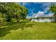 Expansive backyard with lush green grass and mature trees, perfect for outdoor activities at 27359 Whitman Ave, Punta Gorda, FL 33983