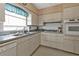 Kitchen with white cabinets, gray countertops, and a built-in oven at 22557 Bolanos Ct, Port Charlotte, FL 33952