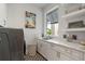 Laundry room with white cabinets, a farmhouse sink, and stylish decor at 2511 Rio Largo Ct, Punta Gorda, FL 33950