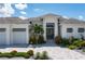 White two-story house with gray roof, double doors, and landscaped yard at 2511 Rio Largo Ct, Punta Gorda, FL 33950