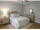 Bedroom decorated with blue accents, two nightstands, ceiling fan, and wood-look floors at 2000 Bal Harbor Blvd # 1012, Punta Gorda, FL 33950