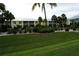 Condominium building surrounded by lush tropical landscaping, including manicured bushes and green grass at 2000 Bal Harbor Blvd # 1012, Punta Gorda, FL 33950
