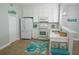 Bright kitchen with white cabinets, stainless steel appliances, and beach-themed decor at 2000 Bal Harbor Blvd # 1012, Punta Gorda, FL 33950