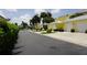 Street view of yellow condominium buildings with white garage doors, tropical landscaping, and palm trees at 2000 Bal Harbor Blvd # 1012, Punta Gorda, FL 33950