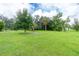 Large grassy side yard with mature trees at 335 Kenova St, Port Charlotte, FL 33954