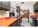 View of kitchen with orange countertops and dark wood cabinets at 335 Kenova St, Port Charlotte, FL 33954