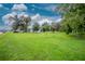 Spacious backyard with lush lawn and mature trees at 335 Kenova St, Port Charlotte, FL 33954