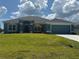 Charming single-story home featuring a lush green lawn and a two-car garage at 10133 Audrey St, Port Charlotte, FL 33981