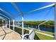 Relaxing canal view from screened patio, featuring boat lift and lush landscaping at 729 Macedonia Dr, Punta Gorda, FL 33950
