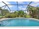 Inviting screened pool with spacious patio area, lush landscaping, and a covered enclosure at 1355 Hempstead Ave, North Port, FL 34286