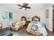 Bright bedroom with two twin beds, ceiling fan, and wood flooring at 17085 Thyme Ct, Punta Gorda, FL 33955