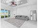 Bright Gathering room with gray sofa, coffered ceiling, and sliding glass doors at 2743 Hopwood Rd, North Port, FL 34287