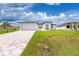 White house with gray roof, paver driveway, and green lawn at 2743 Hopwood Rd, North Port, FL 34287