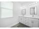 Modern bathroom with double vanity, large mirrors, and stylish flooring at 2743 Hopwood Rd, North Port, FL 34287