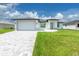 White house with gray roof, paver driveway, and green lawn at 2743 Hopwood Rd, North Port, FL 34287