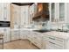 Modern kitchen with white cabinets, copper range hood, and mirrored backsplash at 5000 Palermo Dr, Punta Gorda, FL 33950