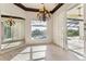 Sunlit dining room with large window, chandelier, and pool view at 5000 Palermo Dr, Punta Gorda, FL 33950