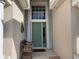 House entry with a green door, a bench, and hurricane shutters at 24059 Buckingham Way, Punta Gorda, FL 33980