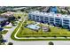 Aerial view of modern condos featuring a pool, outdoor seating, and lush landscaping at 1425 Park Beach Cir # 127, Punta Gorda, FL 33950