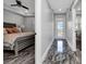 Modern bedroom featuring stylish gray-toned flooring and a hallway leading to a balcony with a scenic view at 1425 Park Beach Cir # 127, Punta Gorda, FL 33950